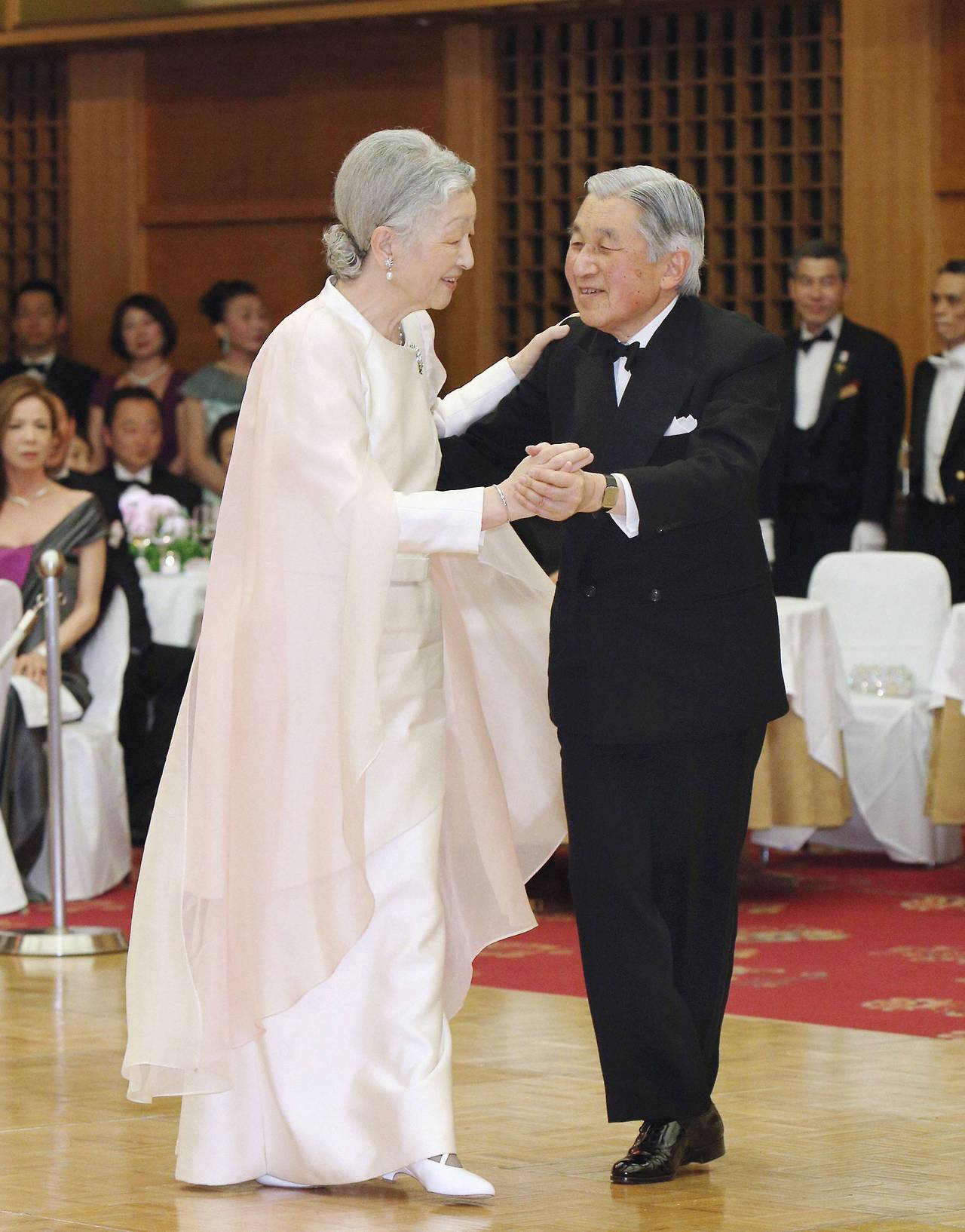 Kyodo photo shows Japan's Emperor Akihito and Empress Michiko dancing at a charity dance party at a hotel in Tokyo