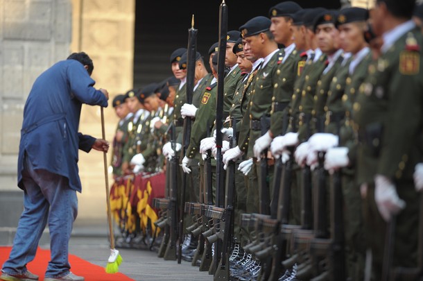 A man sweeps the red carpet in front of